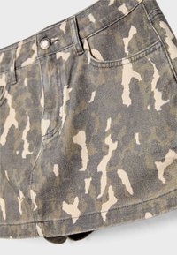 Shorts en denim à motif camouflé gris avec des accents crème, comprenant une fermeture boutonnée, des passants de ceinture et des poches avant.