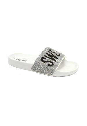 Sandal bianco con un ampio cinturino decorato da strass argentati e scritte nere. Suola liscia con dettagli testurizzati minimi.