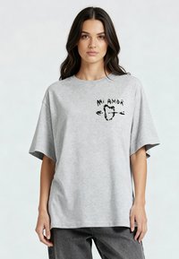 T-shirt gris surdimensionné en coton, avec des manches courtes et un motif sur le devant portant le texte "Mi Amor" et un cœur avec des flèches.