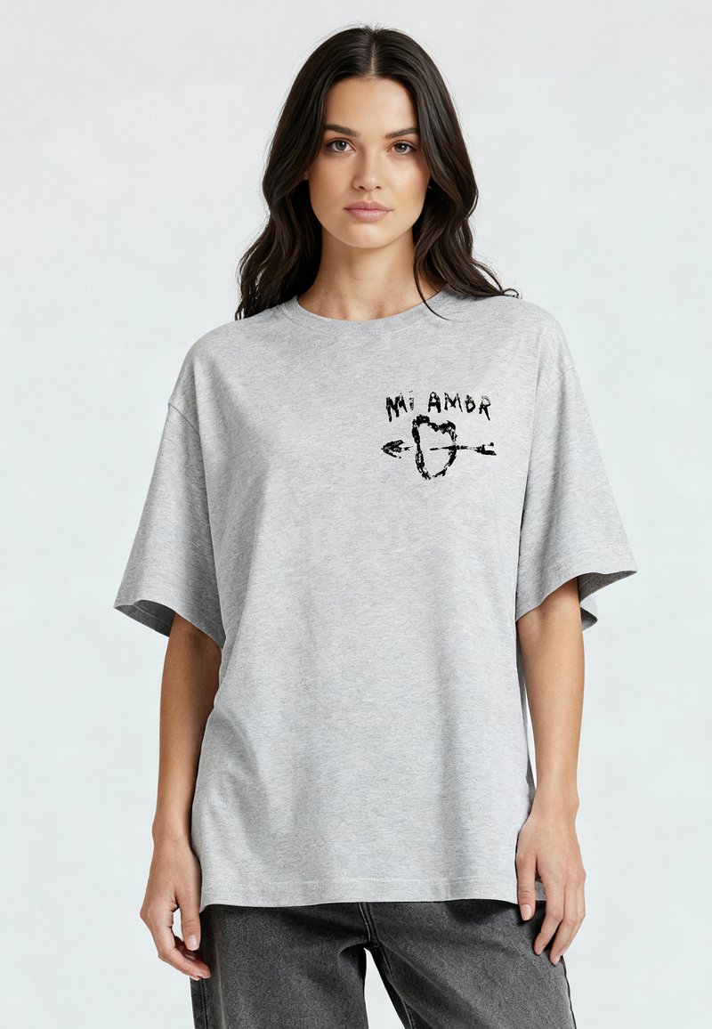 T-shirt gris surdimensionné en coton, avec des manches courtes et un motif sur le devant portant le texte "Mi Amor" et un cœur avec des flèches.