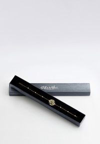 Bracciale albero della vita in oro, contenuto in una scatola nera. Catena delicata con piccole perline, caratterizzata da un intricato design dell'albero come dettaglio centrale.