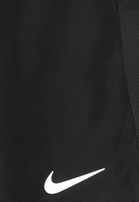 Mustat urheilushortsit, jotka on valmistettu sileästä kankaasta. Sisältää valkoisen Nike-logo painatuksen lähellä alareunaa ja tekstuurilla varustetut sivupaneelit.