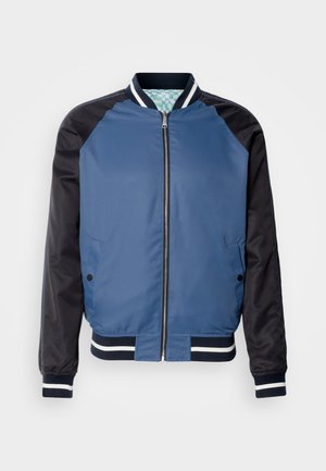 Blue bomber jacket with navy sleeves, ribbed cuffs, and a two-tone design. Features a front zipper and two side pockets. Smooth texture.