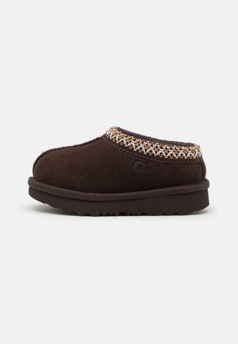 Chausson en daim marron avec un bout arrondi, accent tissé texturé près du haut et logo de la marque visible sur le côté. Semelle en caoutchouc plate.