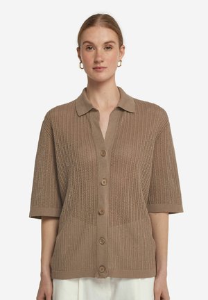 Beige stickad cardigan med korta ärmar, öppen krage och fem stora knappar framtill. Har en strukturerad mönster och en avslappnad passform.