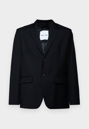 Czarna marynarka w prążki wykonana z gładkiego materiału, z wyłogowym kołnierzem, zapięciem na dwa guziki i dwiema przednimi kieszeniami. Wnętrze ma gładką podszewkę.