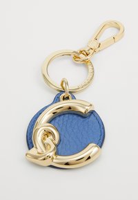 Blå lærnøkkelring med en gullfarget C-formet emblem og rund bakgrunn, utstyrt med en nøkkelring og en svingeklemme for feste.
