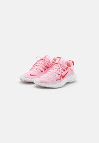 Baskets tissées roses avec semelles en caoutchouc blanches, arborant un swoosh Nike rouge et des lacets assortis. L'intérieur est rembourré pour plus de confort.