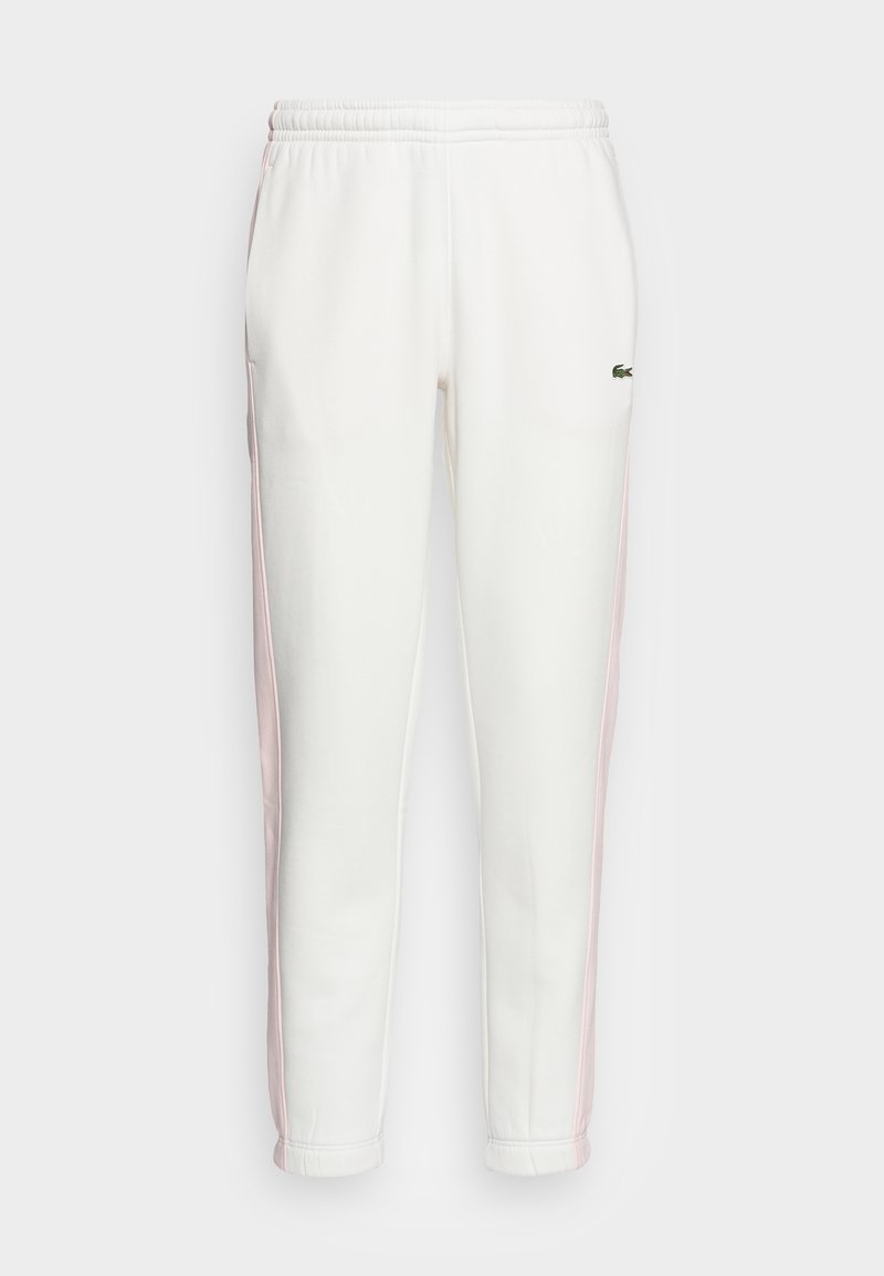 Witte sportieve joggerbroeken met lichtroze zijkanten, elastische tailleband en een klein groen krokodillenlogo op de rechterdij.