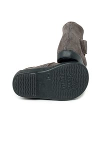 Stivaletti in suede marrone con strap in velcro, suola in gomma testurizzata e marchio visibile sulla suola.