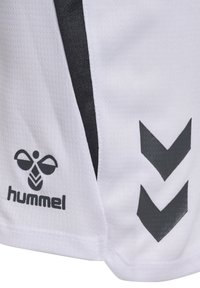 Maglia atletica bianca con accenti neri, realizzata in un tessuto testurizzato, logo Hummel e due strisce a V nere ai lati.