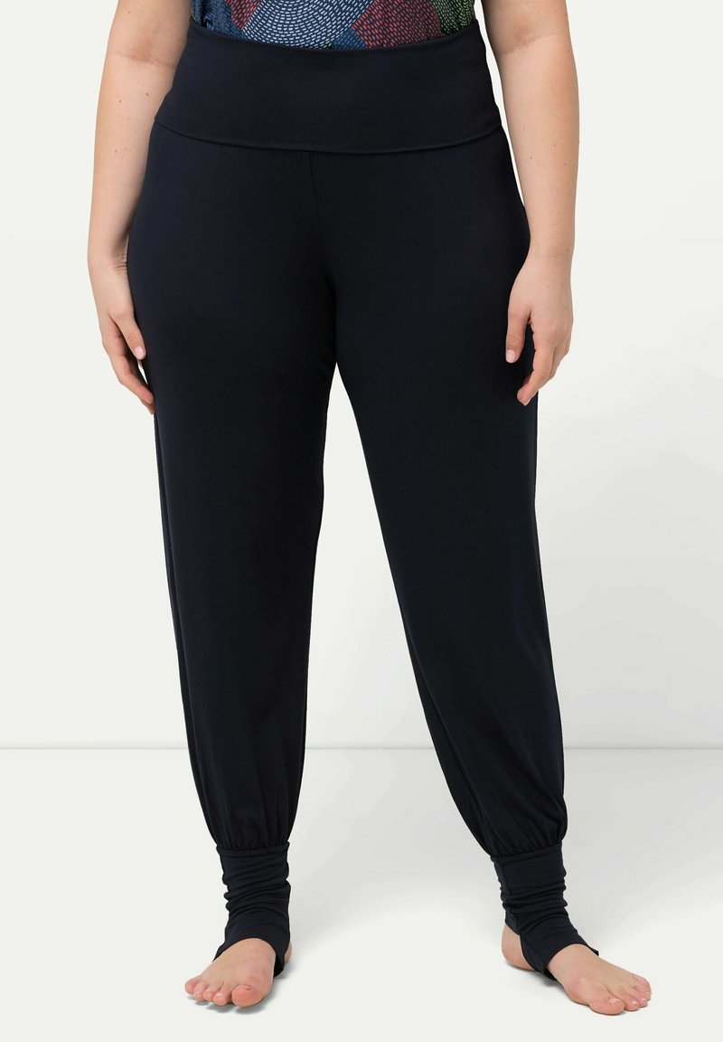 Pantalones jogger negros, elásticos, con una cinturilla ancha y puños ajustados en los tobillos. Textura suave, diseñados para la comodidad y la facilidad de movimiento.