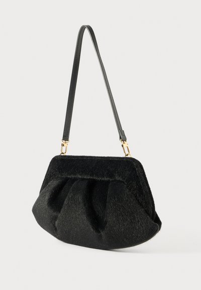Fekete műszőrme kézi táska puha, textúrált felülettel, redőzött dizájnnal és egyetlen fekete bőrpánttal. Arany színű fémalkatrészek díszítik.