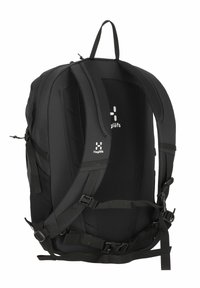 Mochila negra con correas de hombro acolchadas, panel trasero de malla, correas ajustables y un diseño compacto. Presenta el logo de Haglöfs en blanco.
