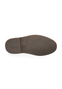 Suela de zapato de goma marrón con una superficie texturizada, que presenta un agarre con un patrón y un área de talón ligeramente elevada para mayor tracción.