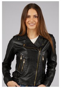Schwarze Leder-Bikerjacke mit strukturiertem, gewebtem Kragen, goldenen Reißverschlussdetails und seitlichen Taschen. Die Jacke hat eine taillierte Passform und lange Ärmel.