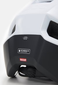 Bijela kaciga s crnim detaljima, sadrži NFC medicinski ID i RECCO logotip, sustav remena za prilagodbu, oznaka veličine označena kao velika (59/62).