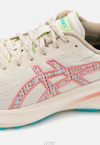 Light beige running shoe with a textured upper, pink and multicolored embroidered accents, layered laces, and a turquoise sole.