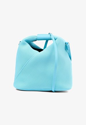 Sac à main en tissu bleu clair texturé avec une forme incurvée et souple, et une fine bandoulière réglable.