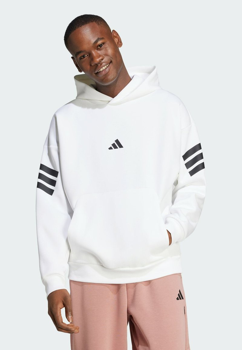 Haut à capuche blanc en tissu doux, avec une poche kangourou, des accents noirs à trois bandes sur les manches et un petit logo sur la poitrine.