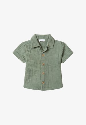 Chemise à manches courtes en coton doux et texturé ; couleur vert sauge avec des boutons en bois et une poche sur le côté gauche de la poitrine.