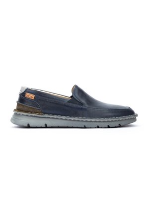 Marineblaue Leder-Slipper mit einer grauen Gummisohle, ausgestattet mit kontrastierendem Stich und einem braunen Logoakzent an der Seite.