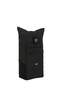 Grand sac à dos noir à rabat, avec une poche frontale, des poches latérales en mesh et une fermeture à sangle en plastique.