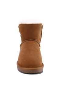 Botín de ante marrón con un suave forro de piel de oveja color canela, punta redondeada y suela de goma texturizada. Diseño simple con un detalle de costura.