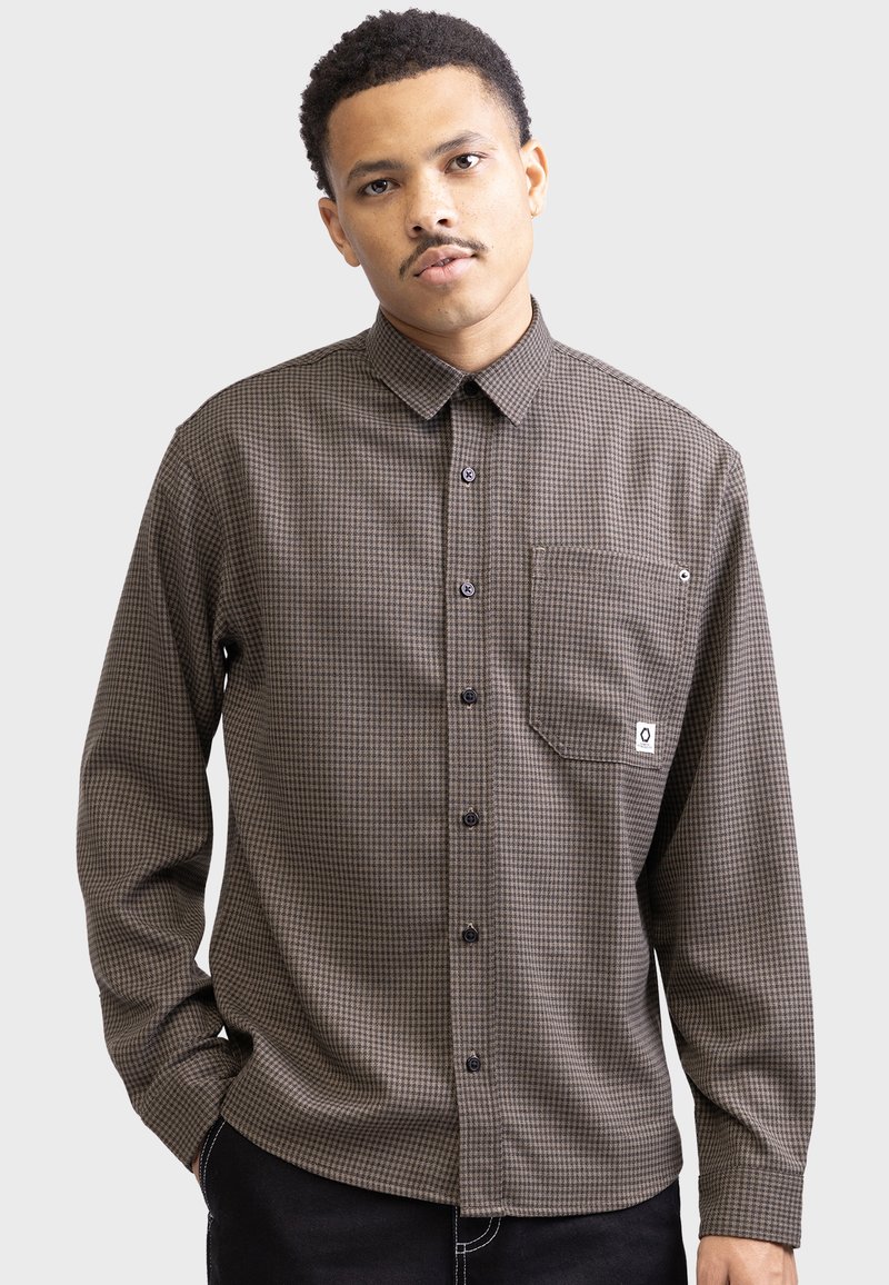 Brown checkered long-sleeve button-up shirt, featuring a pointed collar, a chest pocket, and black buttons. Made of textured fabric.