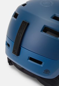 Blauer Helm mit matter Oberfläche. Verfügt über Belüftungsöffnungen, einen schwarzen Verstellknopf und ein Etikett mit der Aufschrift "OWEN." Textilfutter innen.