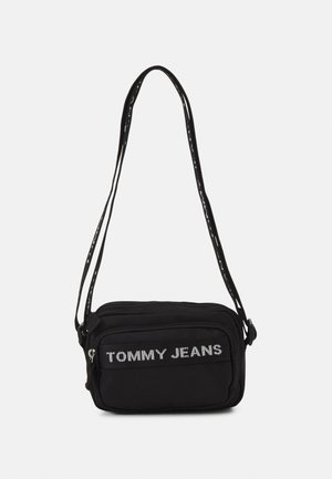 Sort crossbody taske med to lynlåslommer og "Tommy Jeans" broderet på frontlommen med en lang justerbar rem.