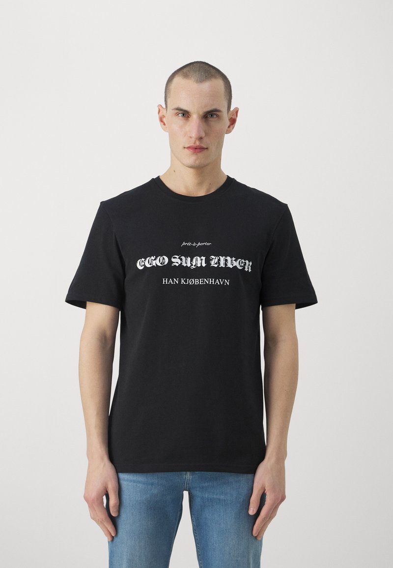 Schwarzes Baumwoll-T-Shirt mit kurzen Ärmeln und rundem Ausschnitt. Mit einem weißen Textdesign, das "EGO SUM URBEN HAN KØBENHAVN" lautet.
