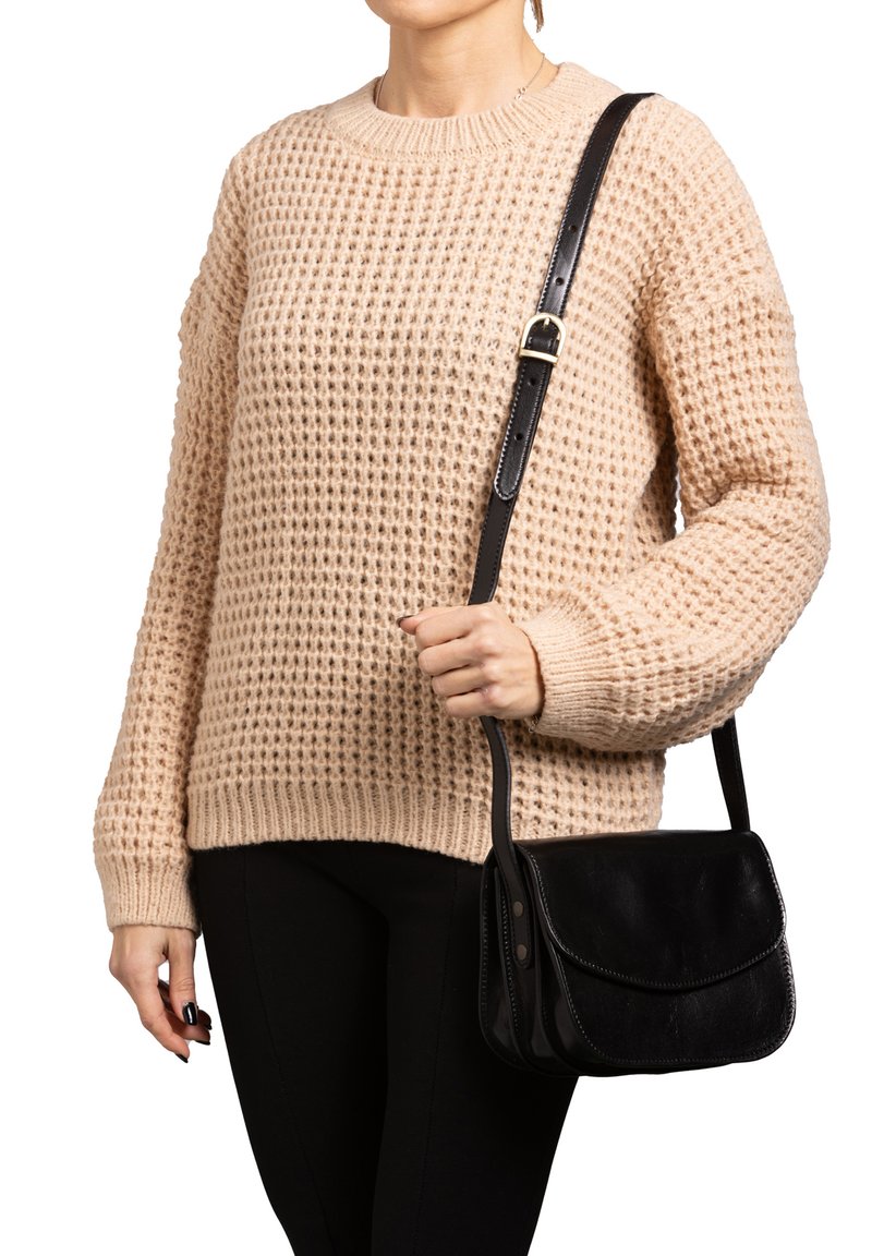 Maglione beige lavorato a maglia con un motivo testurizzato, abbinato a una borsa a tracolla in pelle nera, con tracolla e chiusura a pattina.