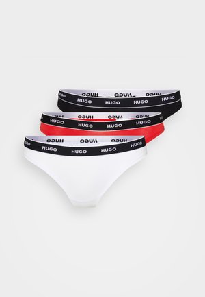 Three pairs of thong underwear in white, red, and black. Each features a soft waistband with "HUGO" printed in black text.