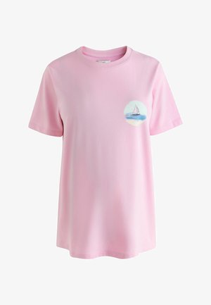 Light pink short-sleeve T-shirt with a small circular sailboat and ocean graphic on the left chest.