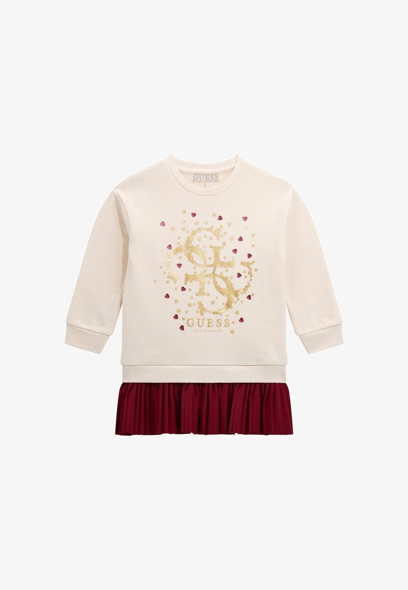 Robe crème à manches longues avec un logo pailleté doré et de petits cœurs rouges, avec une jupe plissée bordeaux attachée à l'ourlet.