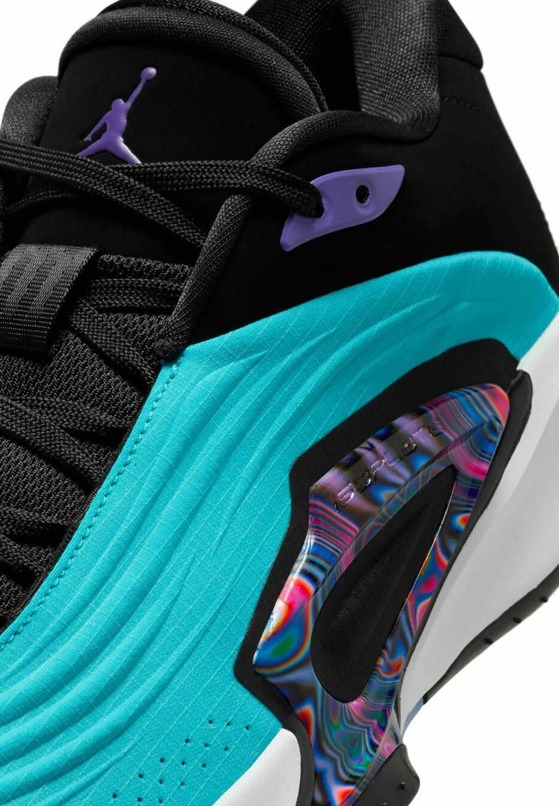 Zwarte sneaker met turquoise accenten, met een ribbeltextuur, paarse hardware en een kleurrijke holografische detail op de tussenzool.