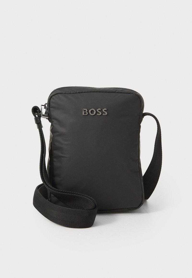 Černá nylonová crossbody taška obdélníkového tvaru, se zipovým uzávěrem, nastavitelným popruhem a embosovaným logem "BOSS" na přední straně.