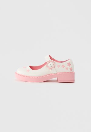White Mary Jane shoe with a pink sole, adjustable strap, and floral embroidery in pink. Rounded toe and textured platform heel.
