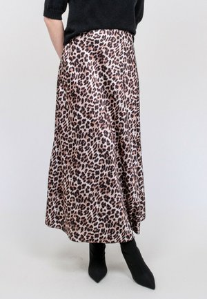 Jupe midi en imprimé léopard en tissu lisse, avec une coupe évasée, présentant des nuances de beige et de noir. Associée à des bottines noires ajustées.