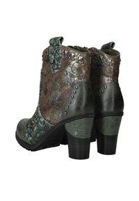 Groene en bruine geprofileerde enkellaarsjes met bloempatronen, metalen studs en blokhakken, in een hoek geplaatst om de achterkant en zijdetails te tonen.