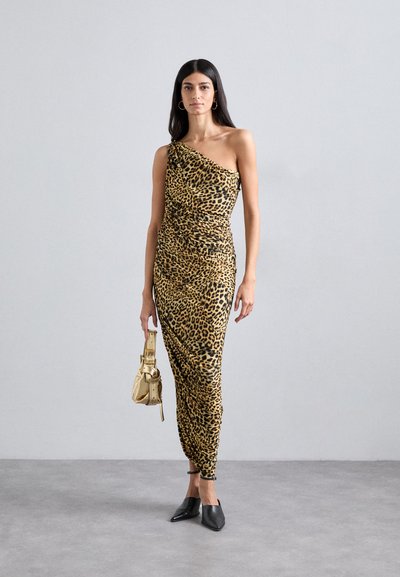 Abito leopardato a spalla unica in marrone e nero, con tessuto drappeggiato e design aderente, abbinato a una piccola borsa dorata e mule nere.