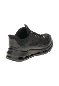 Scarpa da ginnastica nera Skechers con tomaia in rete, collo imbottito e suola spessa e ammortizzata con tasche d'aria, vista dal retro.