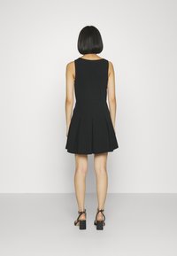 Czarna sukienka bez rękawów z dopasowanym stanem i rozkloszowanym dołem. Charakteryzuje się gładką fakturą oraz plisowanymi detalami w talii.