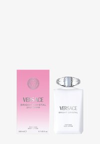Lotion pour le corps Versace Bright Crystal dans un flacon blanc givré avec un bouchon transparent facetté, accompagnée d'une boîte dégradée rose avec des lettres argentées.