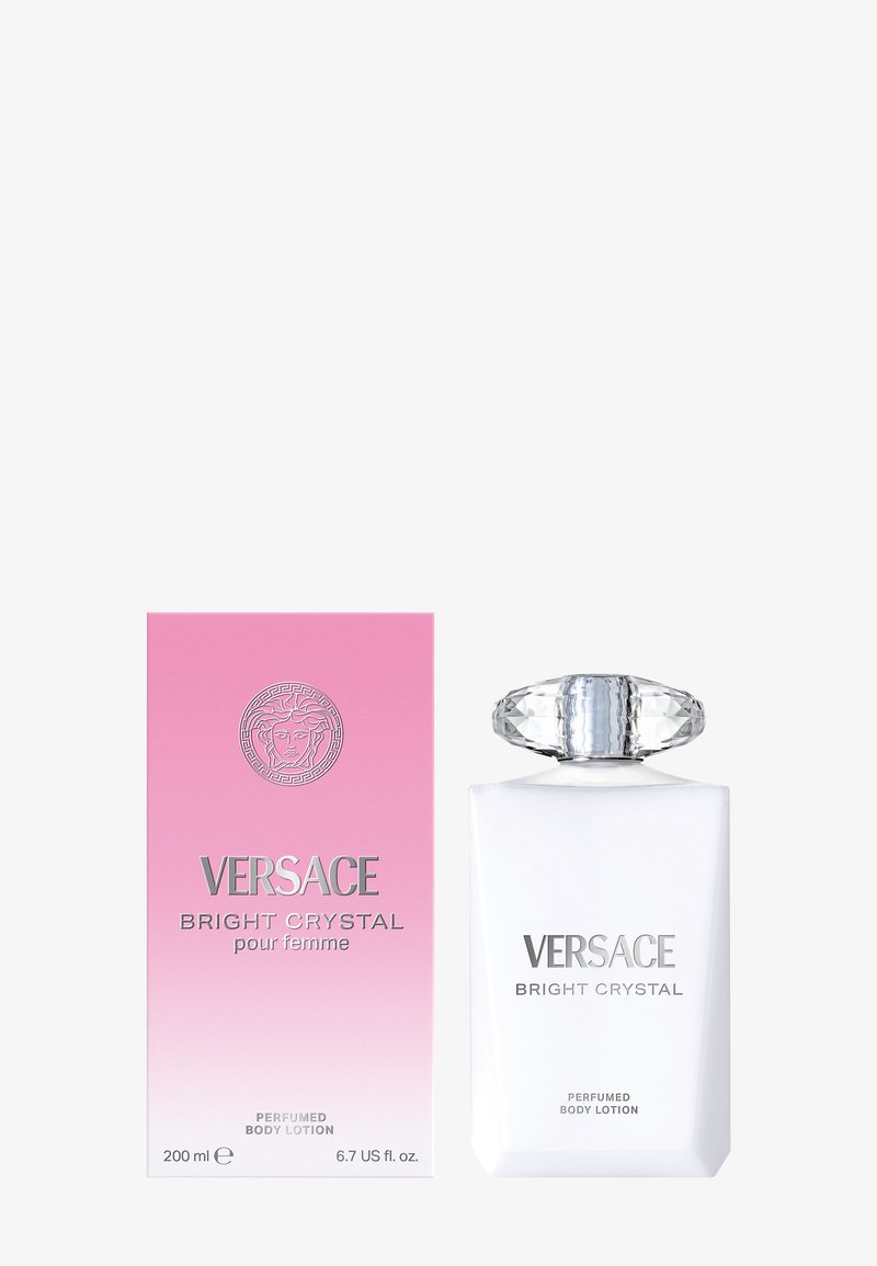Lotion pour le corps Versace Bright Crystal dans un flacon blanc givré avec un bouchon transparent facetté, accompagnée d'une boîte dégradée rose avec des lettres argentées.