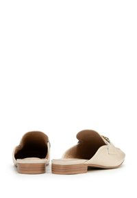Mocassini in pelle beige con forma arrotondata, tacco in legno basso e un'apertura in hardware dorato. Texture liscia con design aperto sul retro.