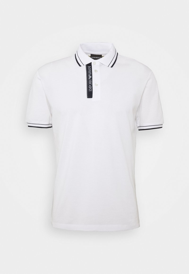 Polo blanc à manches courtes avec bordure noire au col et aux poignets, avec une patte de boutonnage noire et le logo Emporio Armani.