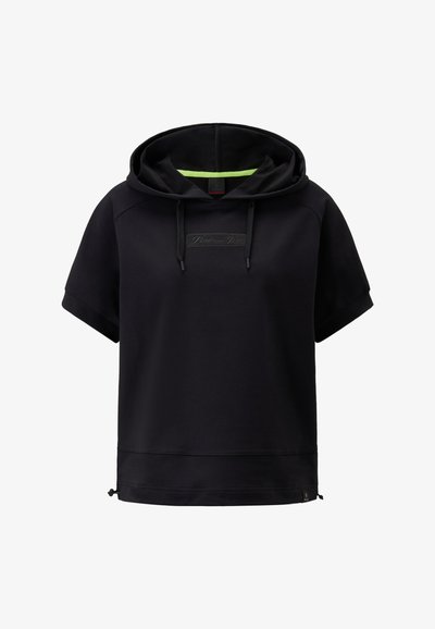 Schwarze Kapuzenjacke mit kurzen Ärmeln, ausgestattet mit einer Kordelzug-Kapuze und einem Logopatch auf der Vorderseite. Sanfte Textur mit einem kontrastierenden grünen Innenfutter.