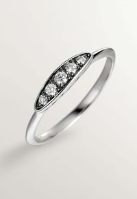 Anillo de plata con un diseño ovalado alargado, engastado con tres piedras preciosas redondas y claras, con acentos en negro que realzan un acabado pulido.